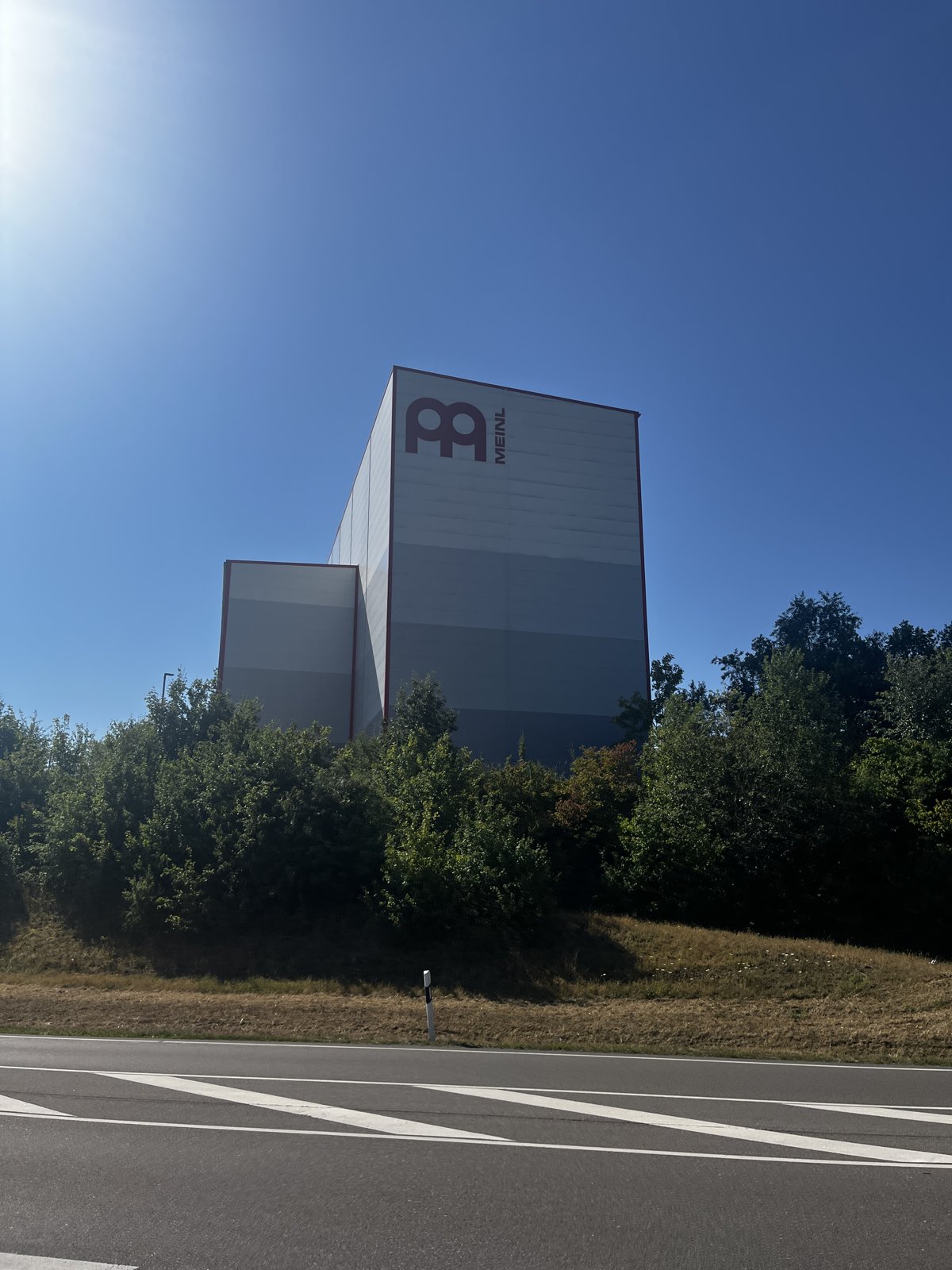 Meinl 本社。青空の下、壁に大きな Meinl ロゴが入った建物
